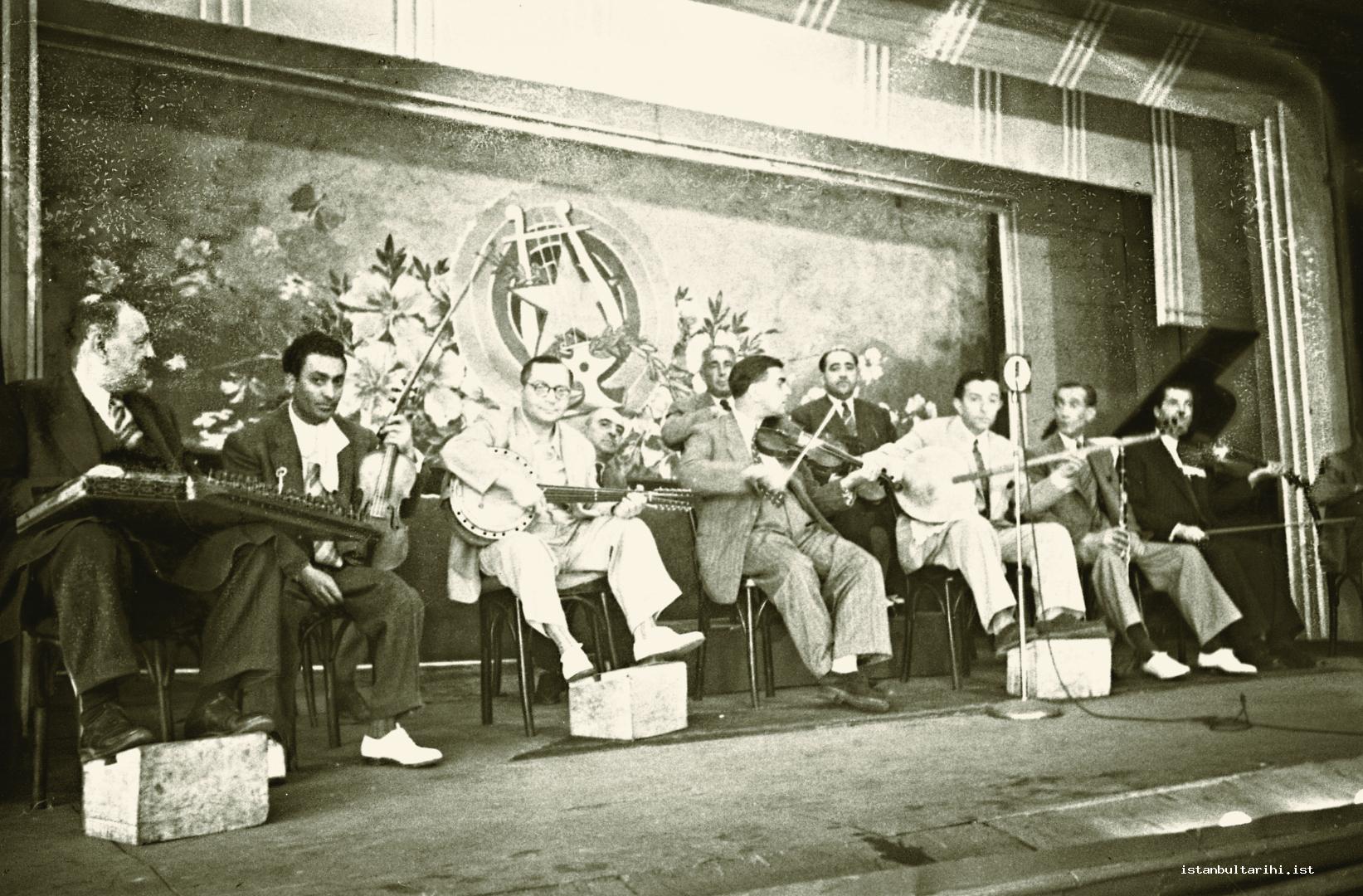 10- Scenes from the life of music in 1940s. Tanbur player and composer Selahattin Pınar and Sa ye Ayla are singing on the stage. There are famous players such as Yorgo  Bacanos among the group of instrument players.