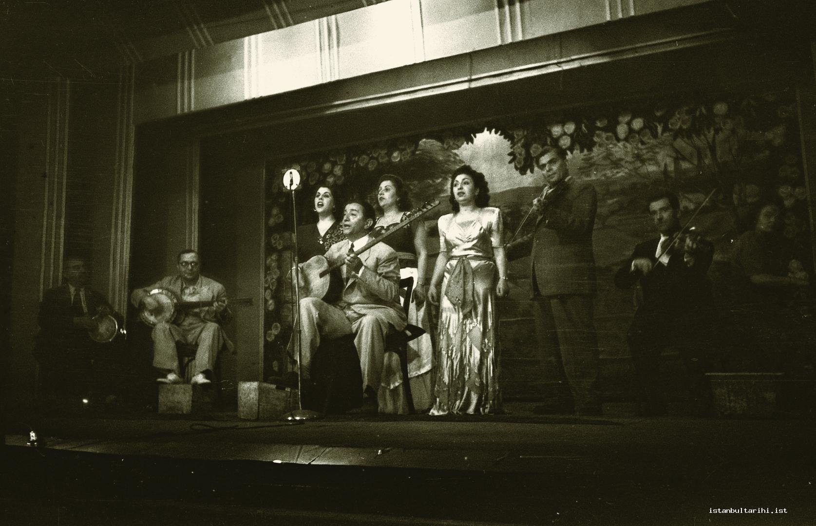 10- Scenes from the life of music in 1940s. Tanbur player and composer Selahattin Pınar and Sa ye Ayla are singing on the stage. There are famous players such as Yorgo  Bacanos among the group of instrument players.