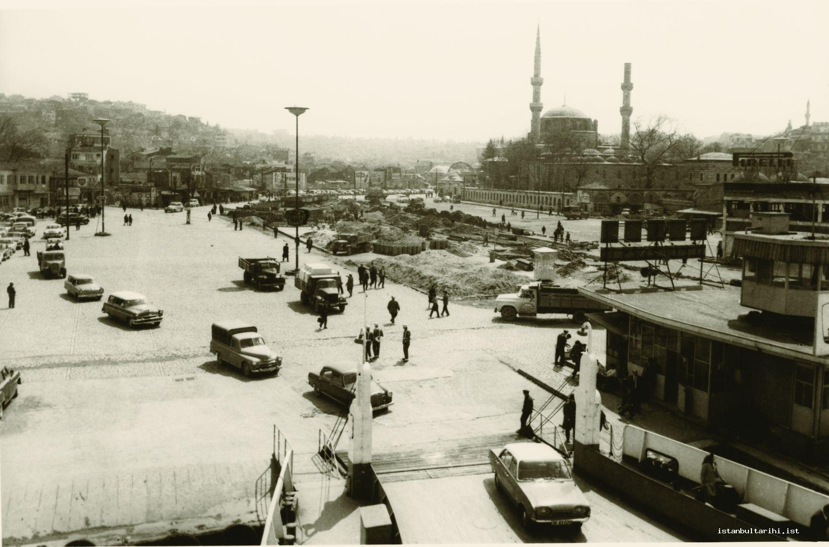 16- Üsküdar pier and Square in 1950s. Gülnuş Emetullah Sultan Mosque is on the right. The cone of its minaret was broken. The tomb of Gülnuş Emetullah Sultan is right
    next to the mosque. The tomb is an open-top building with no ceiling and receiving rain water.
