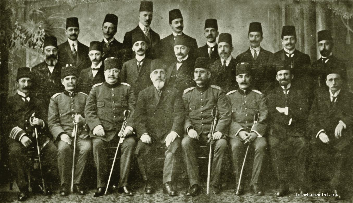 15- The members of the head office of Ottoman Red Crescent: Those who are sitting in the front row: From right to left: The deputy chairman of Red Crescent doctor Besim Ömer Bey, member of the head office and Minister of Public Works Bisarya Efendi, member doctor İsmail Besim Paşa, member Mirliva Nazif Paşa, second chairman and former governor of Hüdavendigar Azmi Bey, member Lambiki Paşa, member doctor Abidin Bey, member doctor Hakkı Şinasi Bey. Those who are standing in the second row: From right to left: member and the member of the Council of State Yusuf Razi Bey, member Kamha Efendi, member of the board of administration and head office engineer Asaduryar Efendi, member doctor Esad Bey, member of the board of administration and head office doctor Cemaleddin Muhtar Bey, member doctor Akil Muhtar Bey, member and Sabah newspaper editor-in-chief Diran Gilikyan Efendi Those who are standing in the back row: From right to left: Head clerk and member doctor Kilisli Rıfat Bey, member Kasım İzzeddin Bey, Member Kamil Ömer Bey, clerk Hamid Bey, member treasurer Keresteciyan Efendi