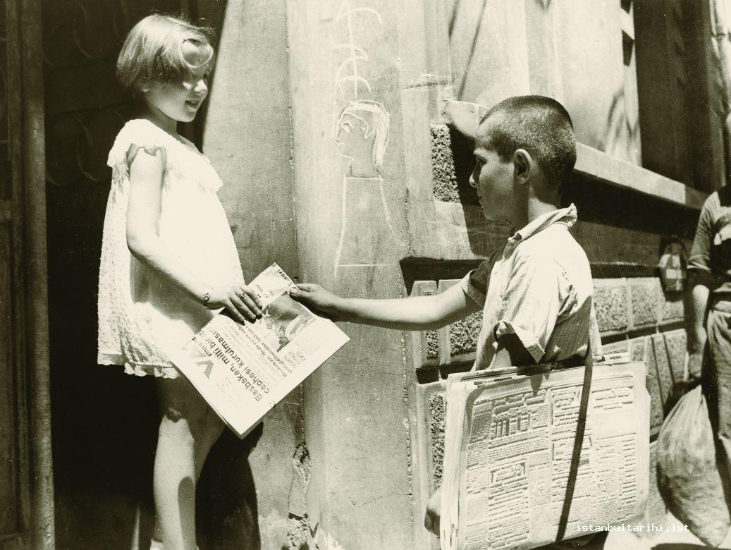 2- Newspaper carrier and a girl picking up the newspaper of her house (Istanbul Metropolitan Municipality, Kültür A.Ş.)