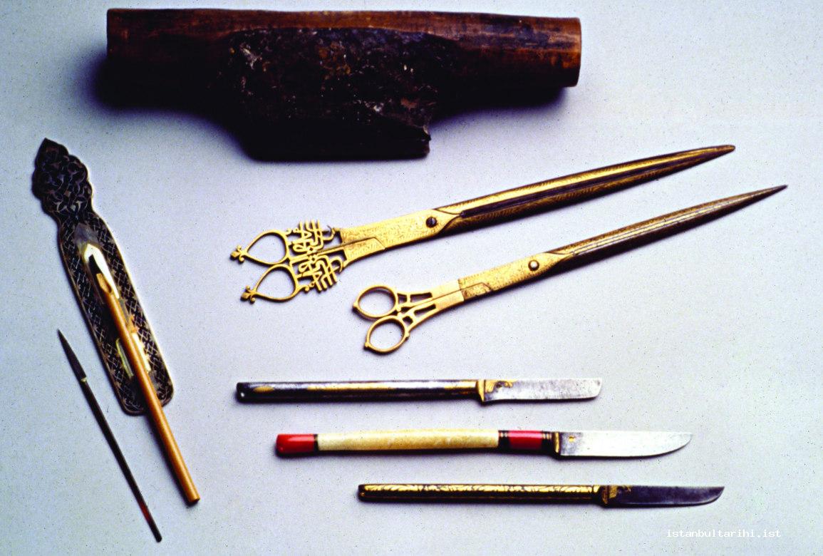 2- Various instruments used in the art of calligraphy: muhra (shell used for giving smoothness and glossiness to paper), paper scissors, a pen on a makta (a bone implement on which reed pens are nibbed), and sharpening Stone